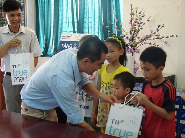 Đại diện Công ty CP sữa TH trao quà tận tay cho các cháu làng trẻ em SOS Hà Nội.